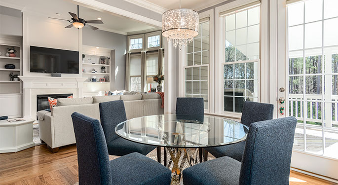 an open living room/dining room with french doors leading to a covered porch